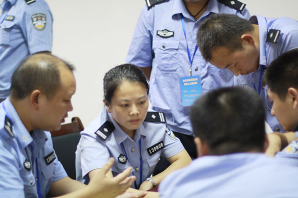 Li Bei talks with her colleagues to try to save a woman wanting to commit suicide in Loudi, Hunan province, in August 2010. She eventually saved the woman from the top of a 50-meter building.(Photo/China Daily)