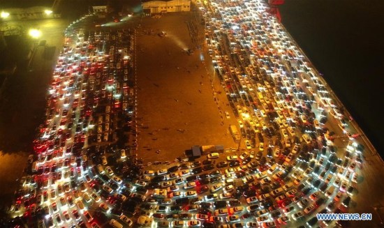 Vehicles wait for ferry service at Xiuying port in Haikou, capital of south China's Hainan Province, Feb. 21, 2018. (Xinhua/Zhao Yingquan)