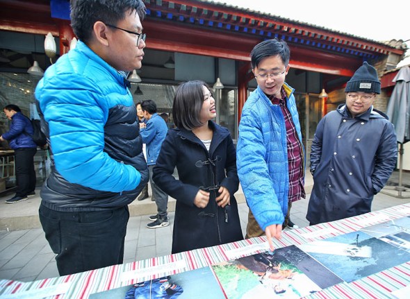 Liu Yuyang (far right) assesses photos by children from rural areas.Photo by Liu Yuyang/For China Daily