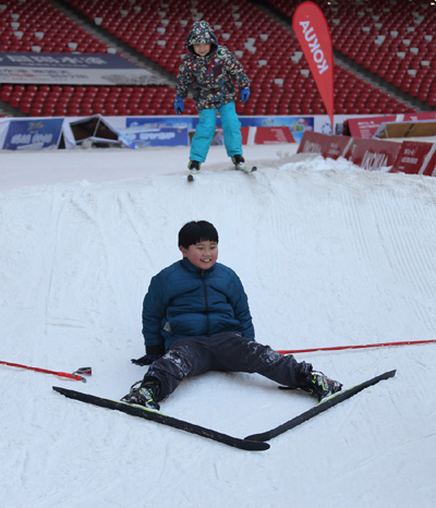 Children get a taste of skiing at the National Stadium, or the Bird's Nest, in Beijing earlier this month. The stadium will serve as the venue for the opening and closing ceremonies of the 24th Winter Olympic Games in 2022. (WANG JING/CHINA DAILY)