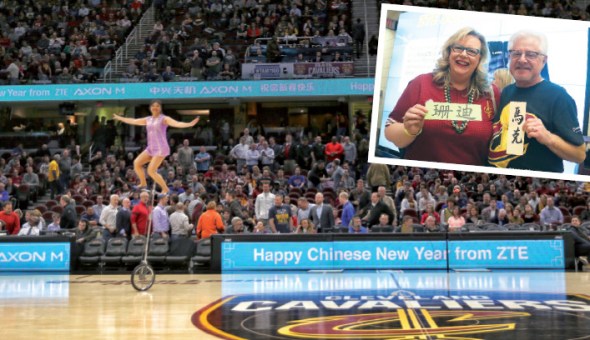 Sandy Maxson and her husband (inset) pose at ZTE's Social Zone, holding their names handwritten in Chinese characters before the tipoff of the NBA game between the Cleveland Cavaliers and the Brooklyn Nets on Tuesday at the Quicken Loans Arena in Cleveland, Ohio. Judy Zhu / China Daily