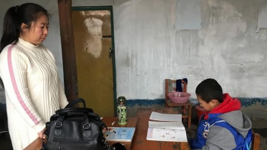 Chen Hongyan guided Wang Hao while he was finishing his homework‍. /Xinhua Photo