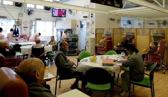 Seniors at a facility in Hung Hom district run by Culture Homes, a nursing home chain in Hong Kong, watch TV in the canteen. （Photo: China Daily/Roy Liu）