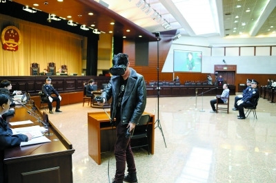 A witness wearing a pair of VR glasses and operating a hand set replicates the crime scenes he had seen on March1, 2018, at a courtroom in Beijing's No. 1 Intermediate People's Court. (Photo/Beijing Evening Post)