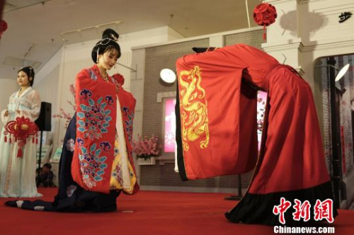 Participants reenact a grand Tang Dynasty-style wedding ceremony at the Shanghai Mass Art Center's Lantern Festival-themed street fair, March 3, 2018. (Photo/Chinanews.com)
