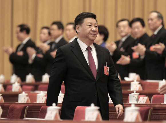President Xi Jinping, also general secretary of the Communist Party of China Central Committee, walks into the conference hall during the first session of the 13th National People's Congress, which opened at the Great Hall of the People in Beijing on Monday. (Photo by Xu Jingxing/China Daily)