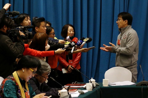 Action movie star Jackie Chan speaks to journalists on the sidelines of a meeting during the first session of the top political advisory body in Beijing on Tuesday. (Jiang Dong/China Daily)