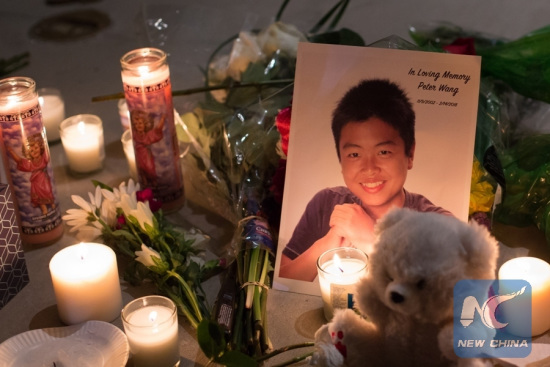 Photo of Peter Wang, a Chinese American victim, is placed during a vigil for the victims of the shooting at Marjory Stoneman Douglas High School, in Pine Trails Park in Parkland, Florida, the United States, on Feb. 15, 2018. (Xinhua/Monica McGivern