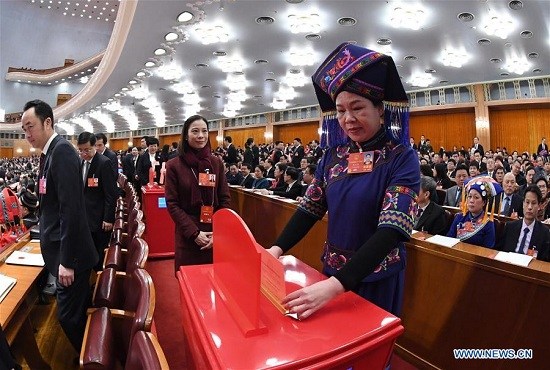 A deputy to the 13th National People's Congress (NPC) casts her ballot on a draft amendment to the country's Constitution at the third plenary meeting of the first session of the 13th NPC in Beijing, capital of China, March 11, 2018. (Xinhua/Rao Aimin)