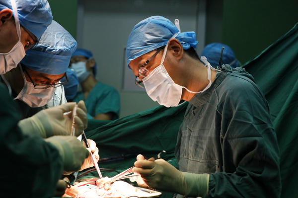 Doctor Chen Jingyu (right) operates on a pneumoconiosis patient at the China-Japan Friendship Hospital in Beijing in February. (Zhu Xingxin/China Daily)