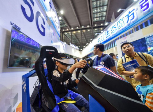 A youngster tries 5G driving technology at an industry expo in Shenzhen, Guangdong Province. (Photo/Xinhua)