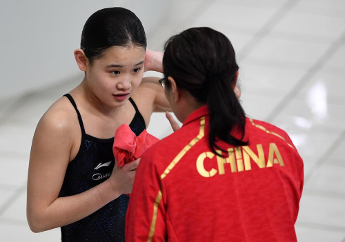 Zhang Jiaqi of China consults with her coach on her way to winning the women's 10m platform at the FINA Diving World Series at the Water Cube in Beijing on Sunday. Photo/Xinhua