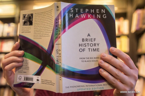A shop assistant poses with A Brief History of Time, the bestselling book of world renowned physicist Stephen Hawking, at a bookshop in London, Britain, on March 14, 2018. (Xinhua/Stephen Chung)