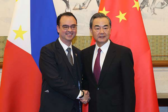 State Counselor and Foreign Minister Wang Yi (right) shakes hands with Philippine Foreign Affairs Secretary Alan Peter Cayetano before their meeting at the Diaoyutai State Guesthouse in Beijing on Wednesday.(Photo by Wang Jing/China Daily)
