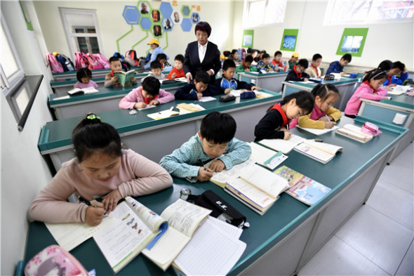 Children in Beijing do their homework after class while waiting for their parents to collect them.( LI XIN/XINHUA)