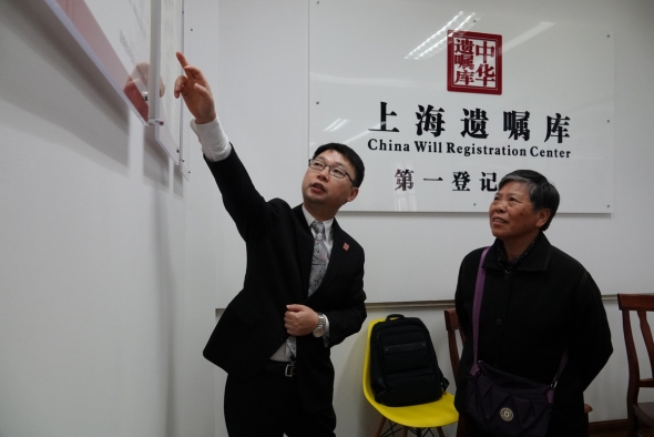 Chen Kai (left), director of the China Will Registration Center's management committee, explains how to draft and store the document to Gong Jinhua, 68, in Shanghai in November.(Photo by Gao Erqiang/China Daily)