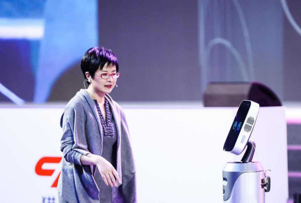 Zhang Quanling, former China Central Television anchorwoman, interacts with the Greetbot developed by Cheetah Mobile in Beijing on Wednesday. (Photo provided to China Daily)