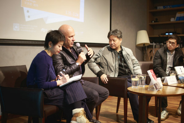 Australian writer Richard Flanagan (second left) and Chinese writer Yu Hua (second right) meet readers at an event in Beijing on Saturday. (Photo provided to China Daily)