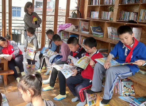 Elementary school students enjoy a library built over a garage in Xiamen, Fujian province, on Saturday, after donating books to the place.(Photo provided to China Daily)