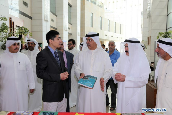 Chinese Ambassador to Kuwait Wang Di (2nd L, front) introduces Chinese books to Secretary-General of the Kuwait National Council for Culture, Arts and Letters (NCCAL) Ali Al-Yoha (3rd L, front) at the exhibition of Chinese books and cultural scenes at the National Library of Kuwait in Kuwait City, Kuwait, March 26, 2018. (Xinhua/Nie Yunpeng)