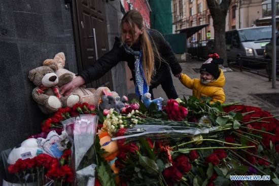 A woman places a doll to the doors of the Kemerovo region representative office in Moscow to mourn the victims of the fire at a shopping mall in Kemerovo, in Moscow, Russia, on March 26, 2018. At least 64 people were killed in a fire in Zimnyaya Vishnya shopping mall in south central Russia's Kemerovo city on Sunday. (Xinhua/Evgeny Sinitsyn)