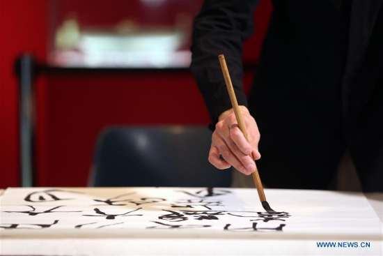 Calligrapher Yuan Qiming works on Chinese calligraphy at Acropolis museum in Athens, Greece, March 23, 2018. Two artists from the Shanghai Museum initiated visitors to the Acropolis Museum in Athens into the traditional Chinese arts of calligraphy and painting. (Xinhua/Marios Lolos)