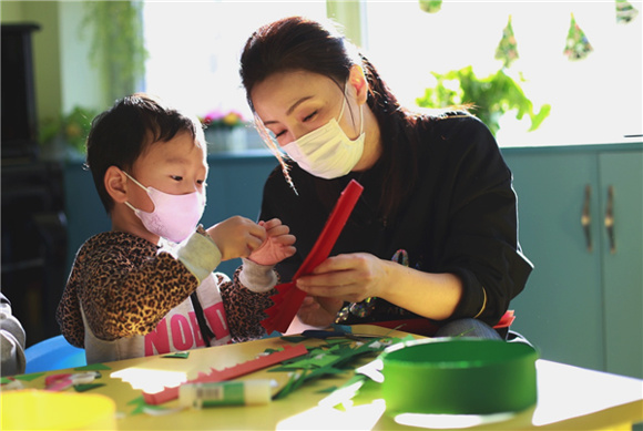A teacher helps a patient during an art class. (Photo provided to China Daily)