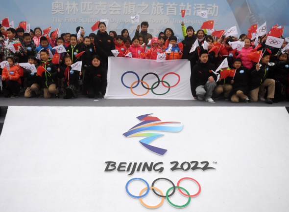 People take a photo with the Olympic flag at the Badaling section of the Great Wall on Feb 27, 2018. Photo/Xinhua