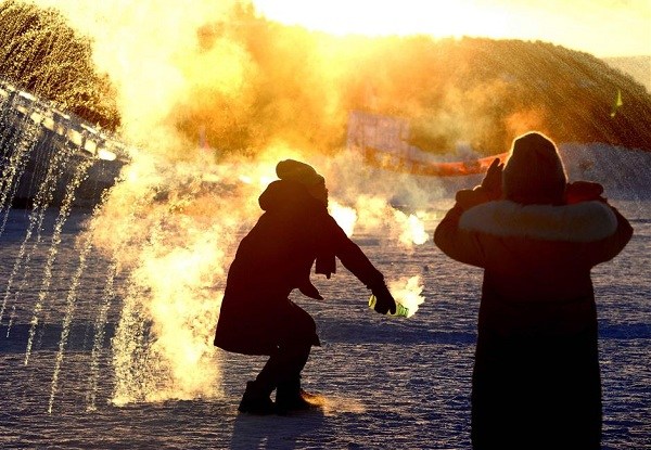 By splashing water into the air, a tourist has created a "snow firework" at dusk as the temperatures drop deeper. (Xinhua)