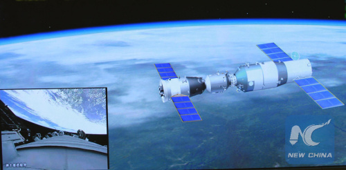 Photo taken on June 13, 2013 shows the screen at the Beijing Aerospace Control Center showing the Shenzhou X manned spacecraft conducting an automated docking with the orbiting Tiangong I space module and the view outside the propelling module of the Shenzhou X manned spacecraft (L, down). (Photo/Xinhua)