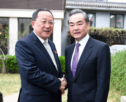 State Councilor and Foreign Minister Wang Yi (right) shakes hands with Ri Yong-ho, foreign minister of the Democratic People's Republic of Korea, on Tuesday in Beijing. (Wang Zhuangfei/China Daily)