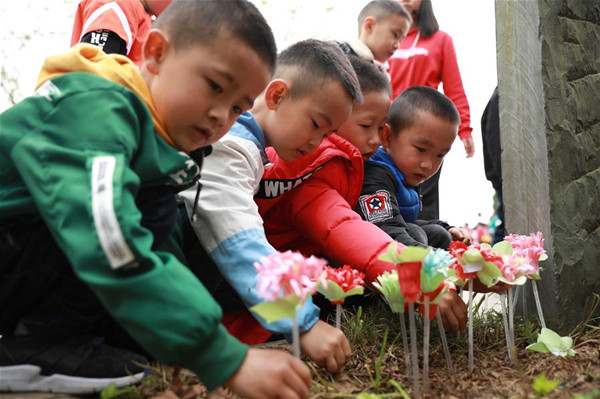 Children lay paper flowers at the tomb of martyrs in Danzhai County, southwest China's Guizhou Province, April 4, 2018. People mourn for the deceased as the Qingming Festival, the Chinese tomb-sweeping day, approaches. (Xinhua/Tang Ke)