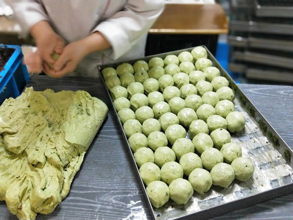 “Qingtuan” rice cakes are being made in a bakery shop in Shanghai around Qingming Festival. (Photo/CGTN)