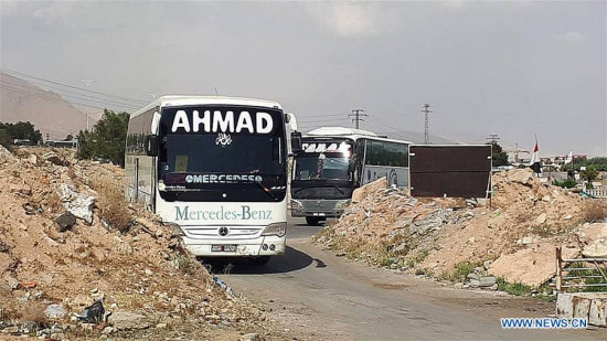 Buses to evacuate militants of the Islam Army as well as the kidnapped people enter the Wafideen area near Douma, northeast of Damascus, Syria, on April 8, 2018. (Xinhua/Ammar Safarjalani)