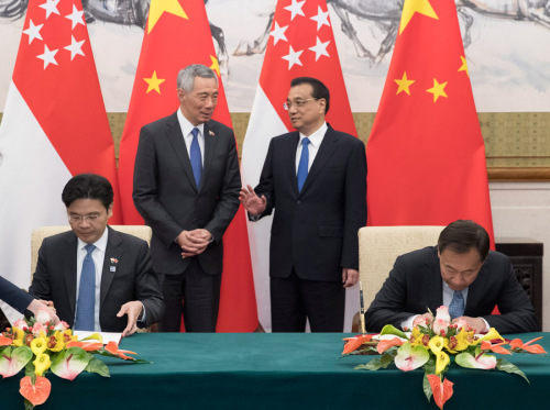 Premier Li Keqiang talks with visiting Singapore Prime Minister Lee Hsien Loong during the signing of two documents on third market cooperation and culture heritage protection between the two countries. (Photo/Xinhua)
