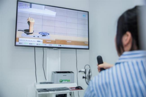 A patient using the game-like system to perform upper limb rehabilitation. (Photo/Shine.cn)