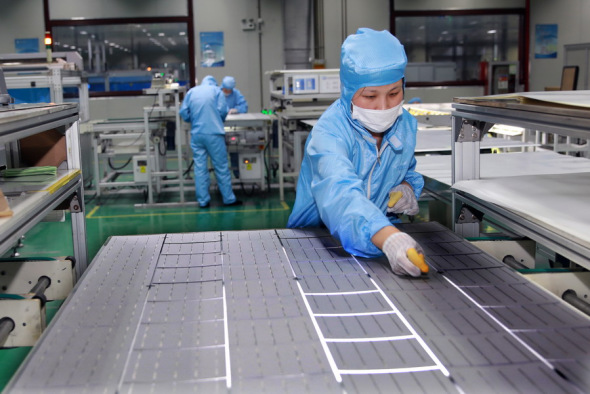 An employee puts finishing touches to photovoltaic products at a facility of Shenzhou New Energy Co in Lianyungang, Jiangsu province. (Photo for China Daily/Si Wei)