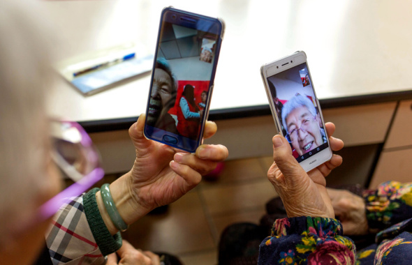 Two elderly women show how they use their smartphones for video chats during an internet class for senior citizens in Taiyuan, Shanxi province. Photo/China Daily)