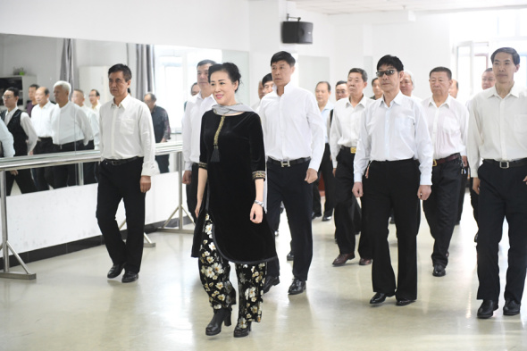Han Ming gives a modeling lesson to her male students at Harbin University for Seniors in Harbin, Heilongjiang province. (LIU YANG/FOR CHINA DAILY)