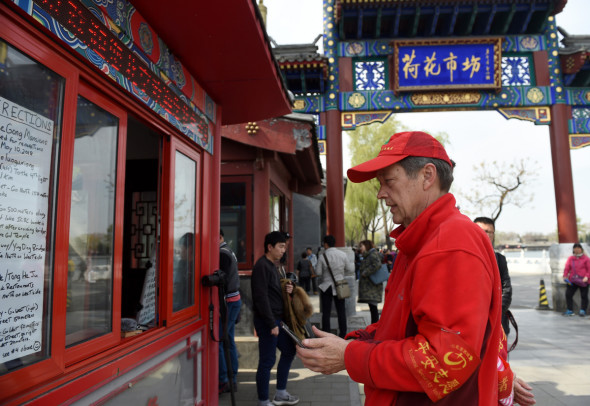 Gao Tianrui sits in the volunteer box at the Lotus Market. (Photo/Xinhua)