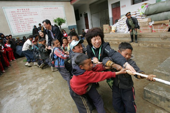 Zhang joins a tug-of-war at a primary school in Liangshan. (Photo/China Daily)