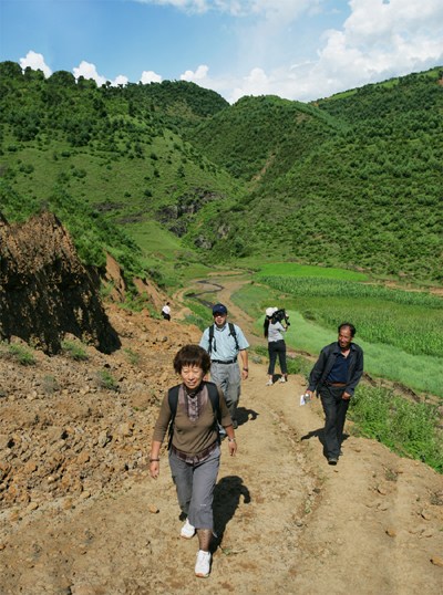 张在2006年步行去一个偏远的村庄。（照片/中国日报）
