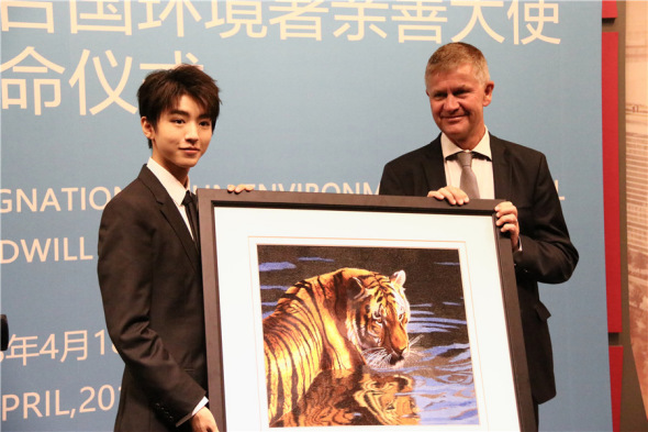Karry Wang gives Eric Solheim a Suzhou embroidery tiger as a gift, which Solheim says he will put on the wall of UNEP headquarters in Nairobi, Kenya. (Photo: chinadaily.com.cn/Yan Dongjie)