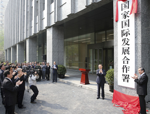 Yang Jiechi, director of the Office of the Foreign Affairs Commission of the CPC Central Committee, and State Councilor and Foreign Minister Wang Yi (right) launch the China International Development Cooperation Agency on Wednesday. (FENG YONGBIN/CHINA DAILY)