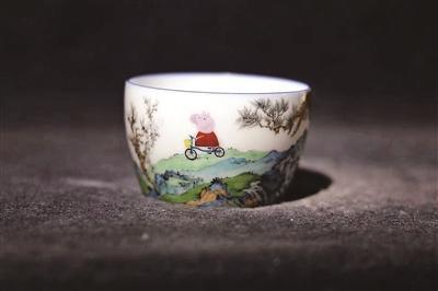 A white porcelain cup painted with the English cartoon figure Peppa Pig riding a bicycle through grassland. (Photo: Beijing Youth Daily)