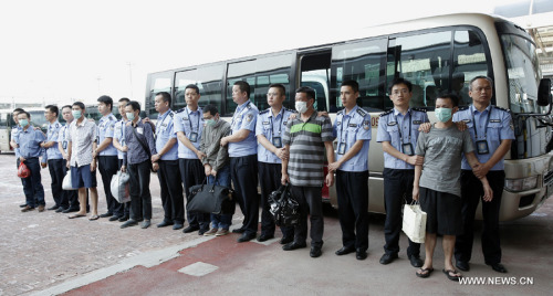 Six fugitives involved in economic crimes are taken back under escort from Indonesia at Capital International Airport in Beijing, June 21, 2015. (Photo/Xinhua)