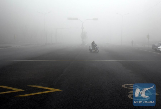 File Photo: A man rides in heavy fog and haze in Jinan City, capital of east China's Shandong Province, Jan. 4, 2017. The provincial meteorological observatory issued a red alert for fog and extended its orange alert for smog on the day. (Xinhua/Zhu Zheng)