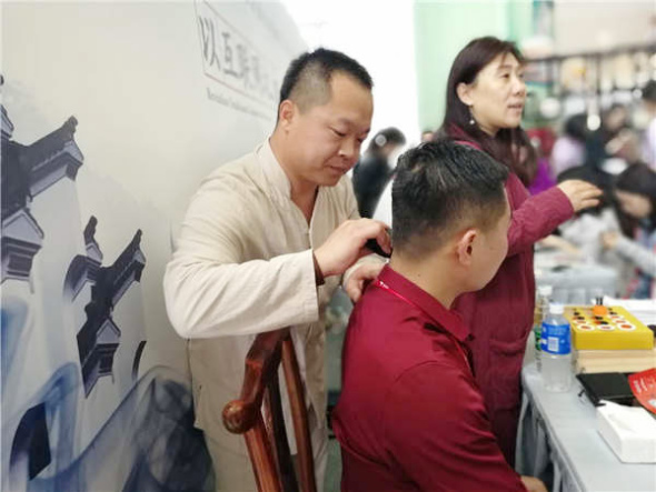 A visitor experiences moxibustion during the ICH show. (Photo provided to chinadaily.com.cn)