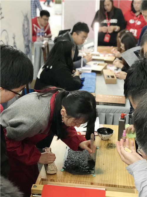 Visitors experience woodblock painting during the show. (Photo provided to chinadaily.com.cn)