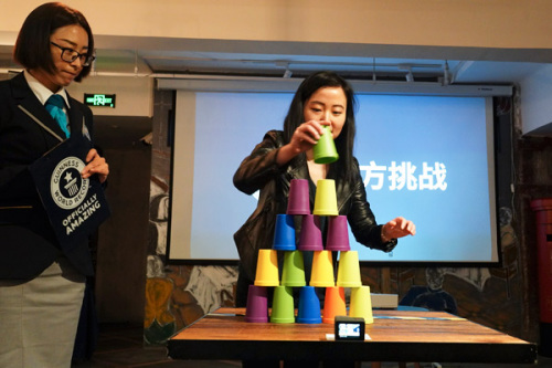 A Guinness World Records official supervises a cup-stacking challenge at a news conference on Wednesday. (Photo by Gao Erqiang/China Daily)